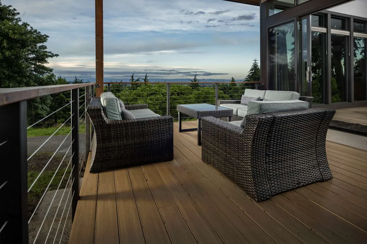 An exterior seating area featuring wicker chairs and a wooden table, all facing a dramatic view of the horizon. The setting captures the calming ambiance of being outdoors, ideal for watching sunsets or stargazing at night, with a serene and inviting mood.