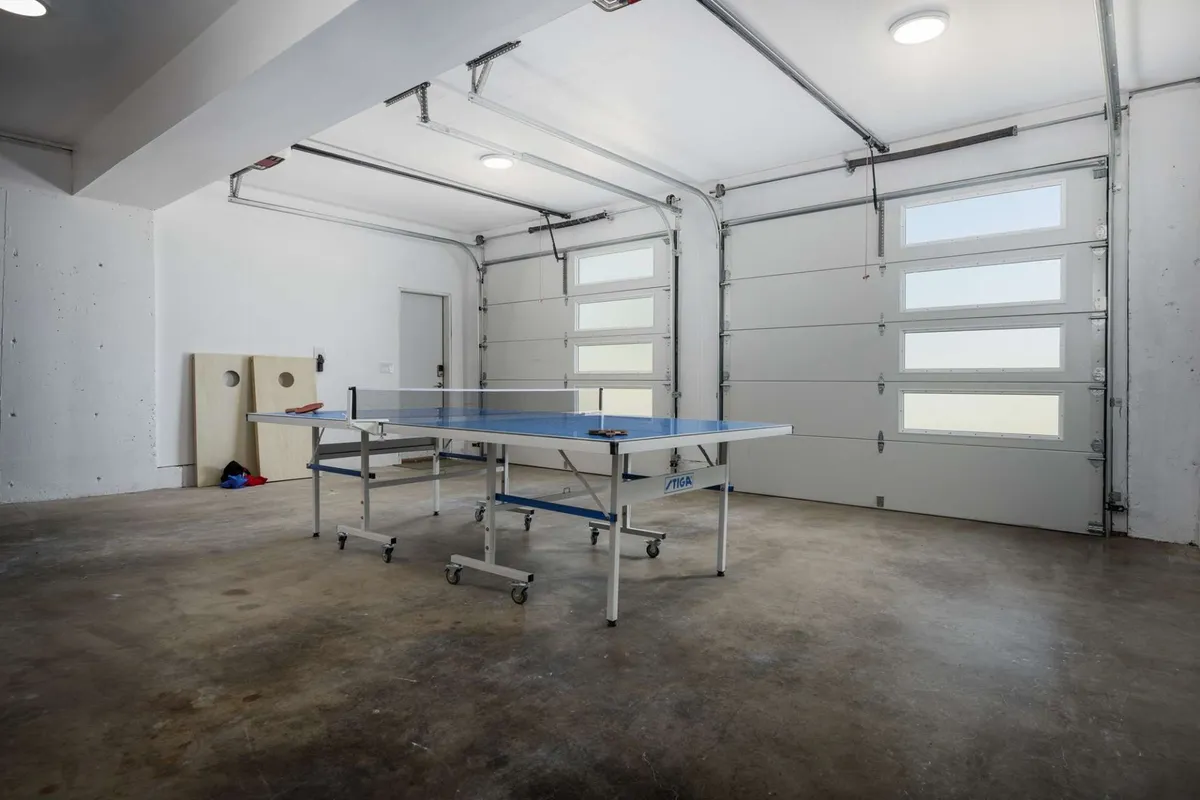 An interior shot of the finished garage transformed into a lively game lounge, equipped with a ping pong table and modern fixtures. The space is bright, casual, and perfect for friendly competition or informal gatherings.